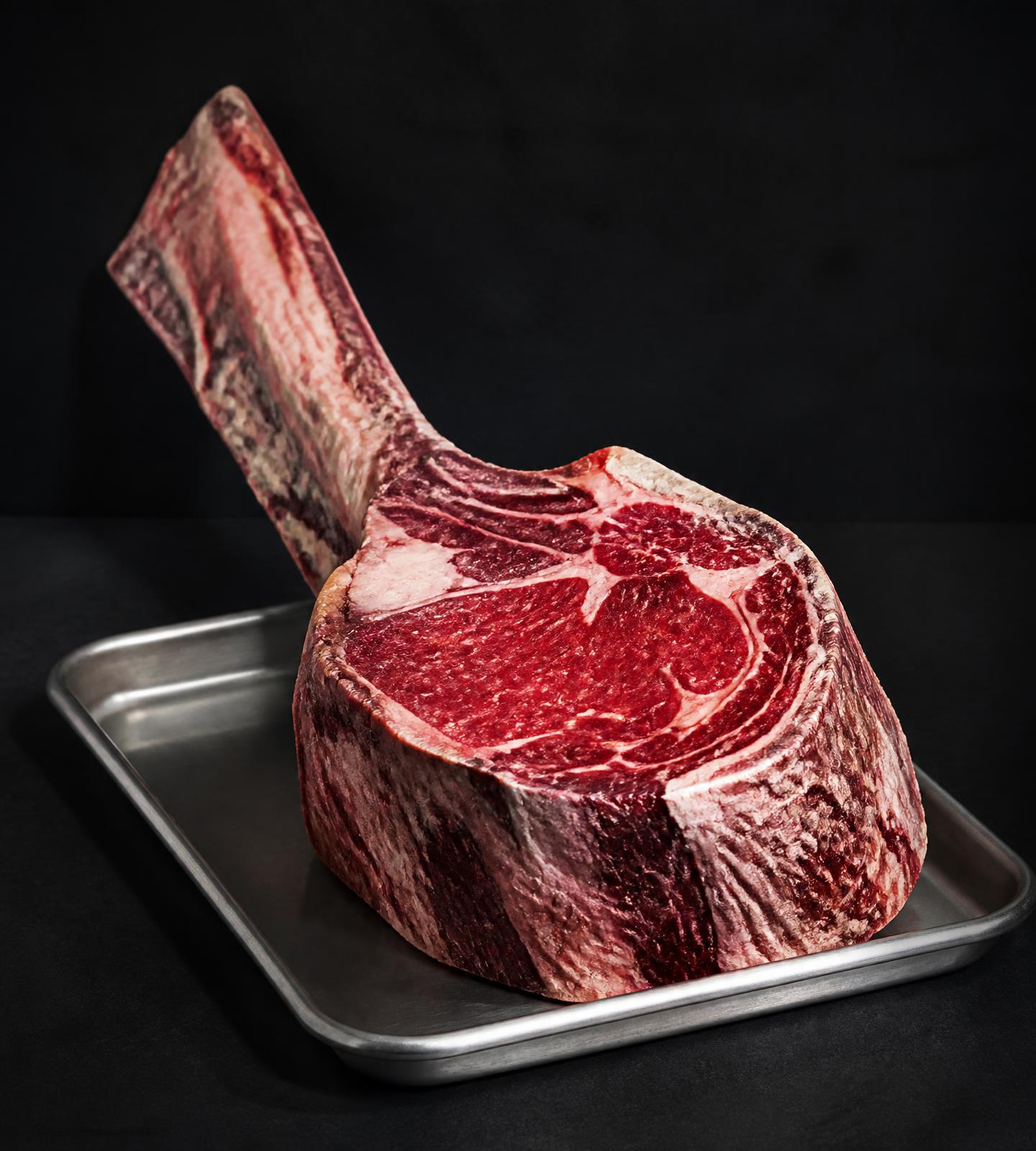 Ein enormes Dry-Aged-Ribeye auf einem Edelstahltablett