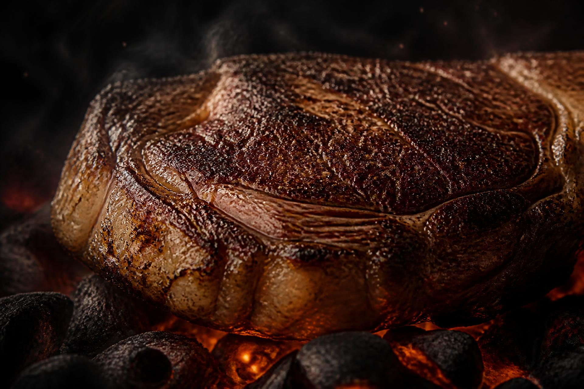 Riesiges Ribeye mit dunkler Kruste über offener Glut